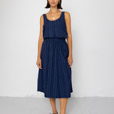 Woman wearing a navy blue sleeveless top and skirt set against a white background