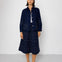 Person wearing a dark blue outfit with a jacket and skirt on a white background