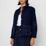 Woman wearing a navy blue patterned outfit on a white background
