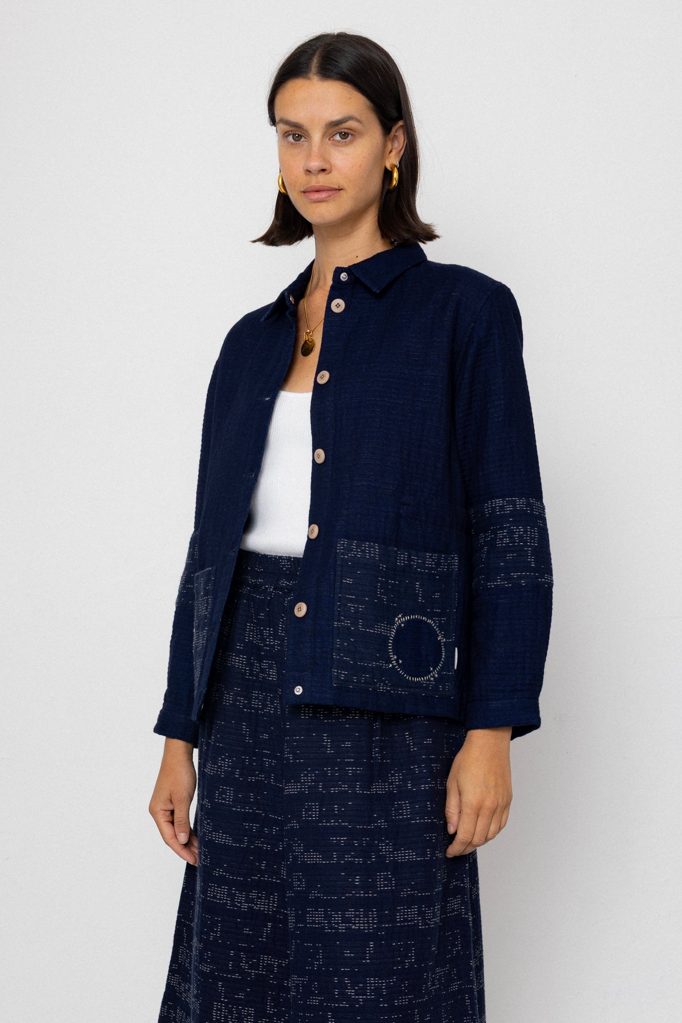 Woman wearing a navy blue patterned outfit on a white background