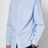 Light blue button-up shirt worn by a person on a plain background
