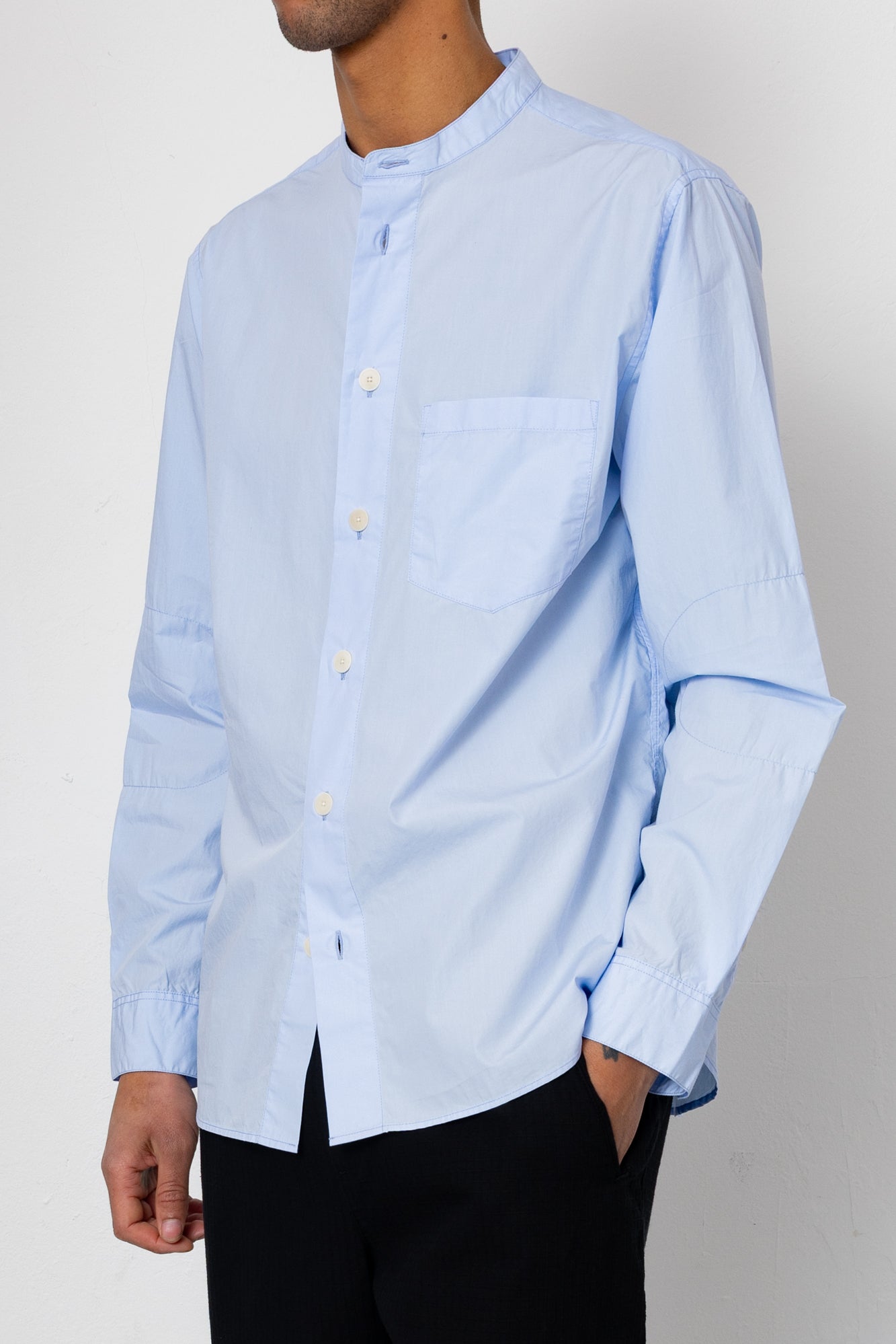 Light blue button-up shirt worn by a person on a plain background