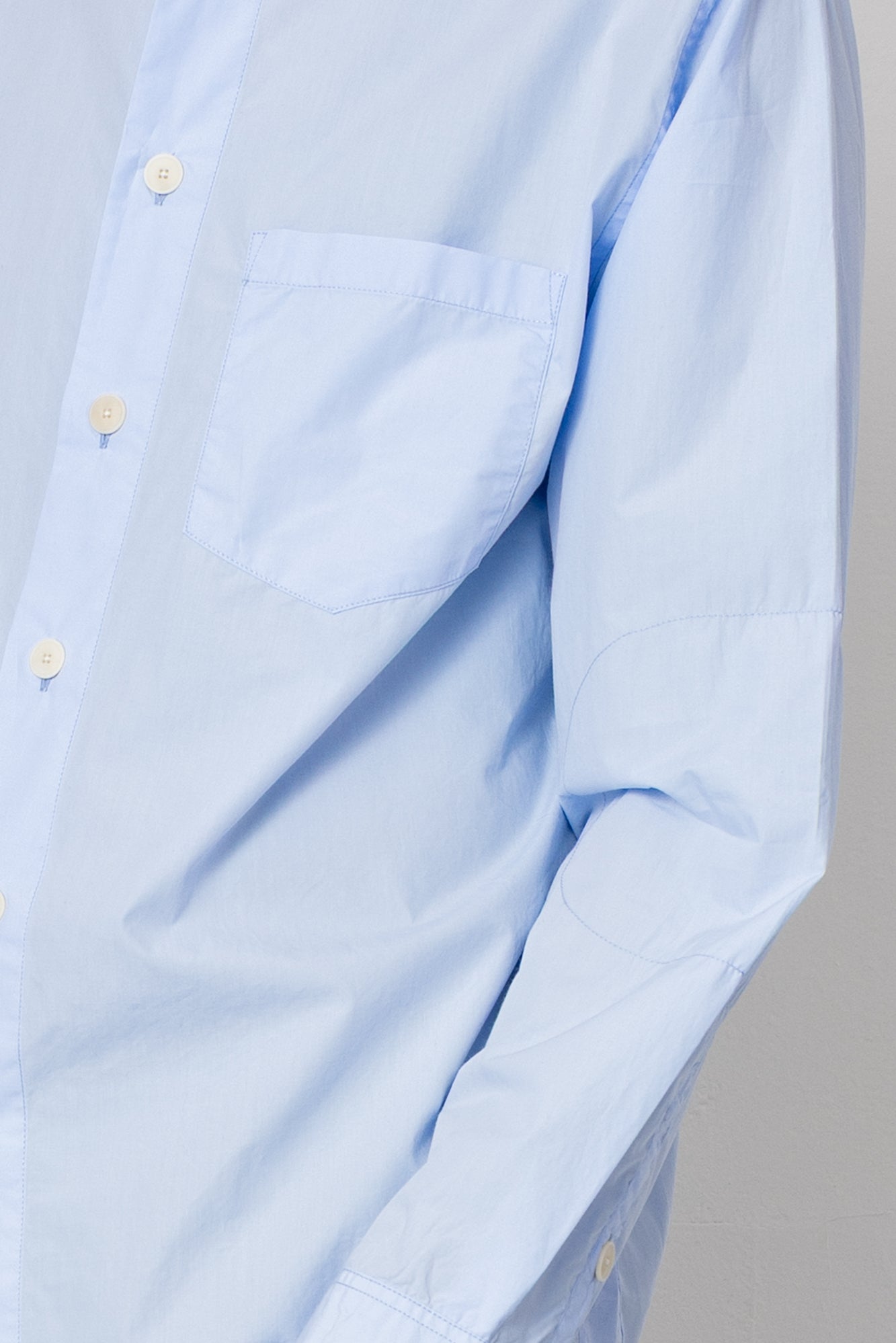 Close up of sleeve detail on light blue shirt