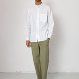 Man wearing a white shirt and green pants against a white background