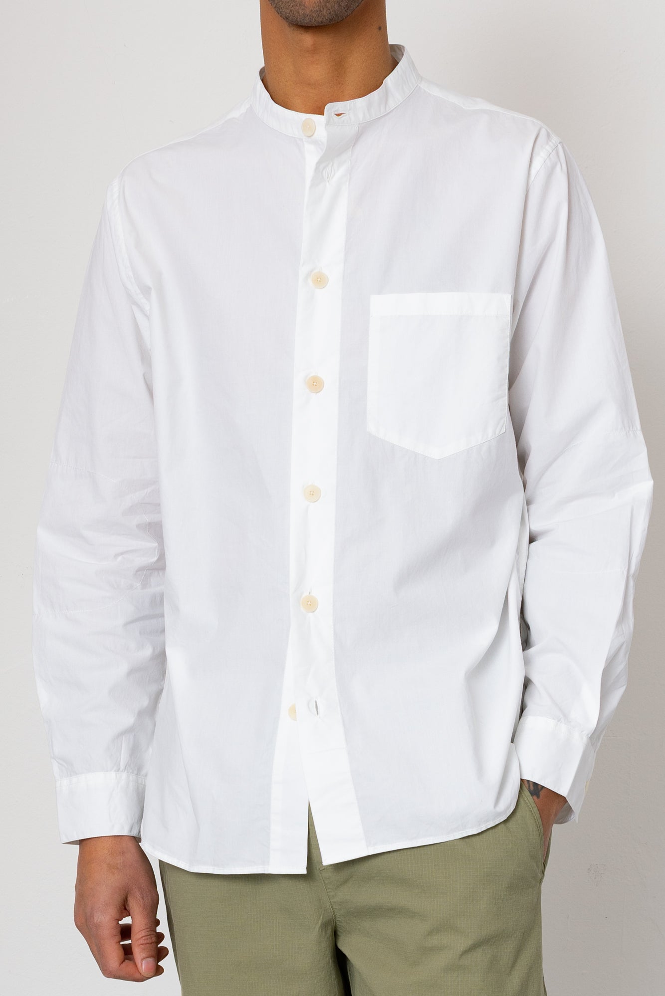 White button-up shirt worn by a person on a plain background