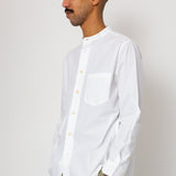 Man wearing a white shirt and beige pants against a plain background