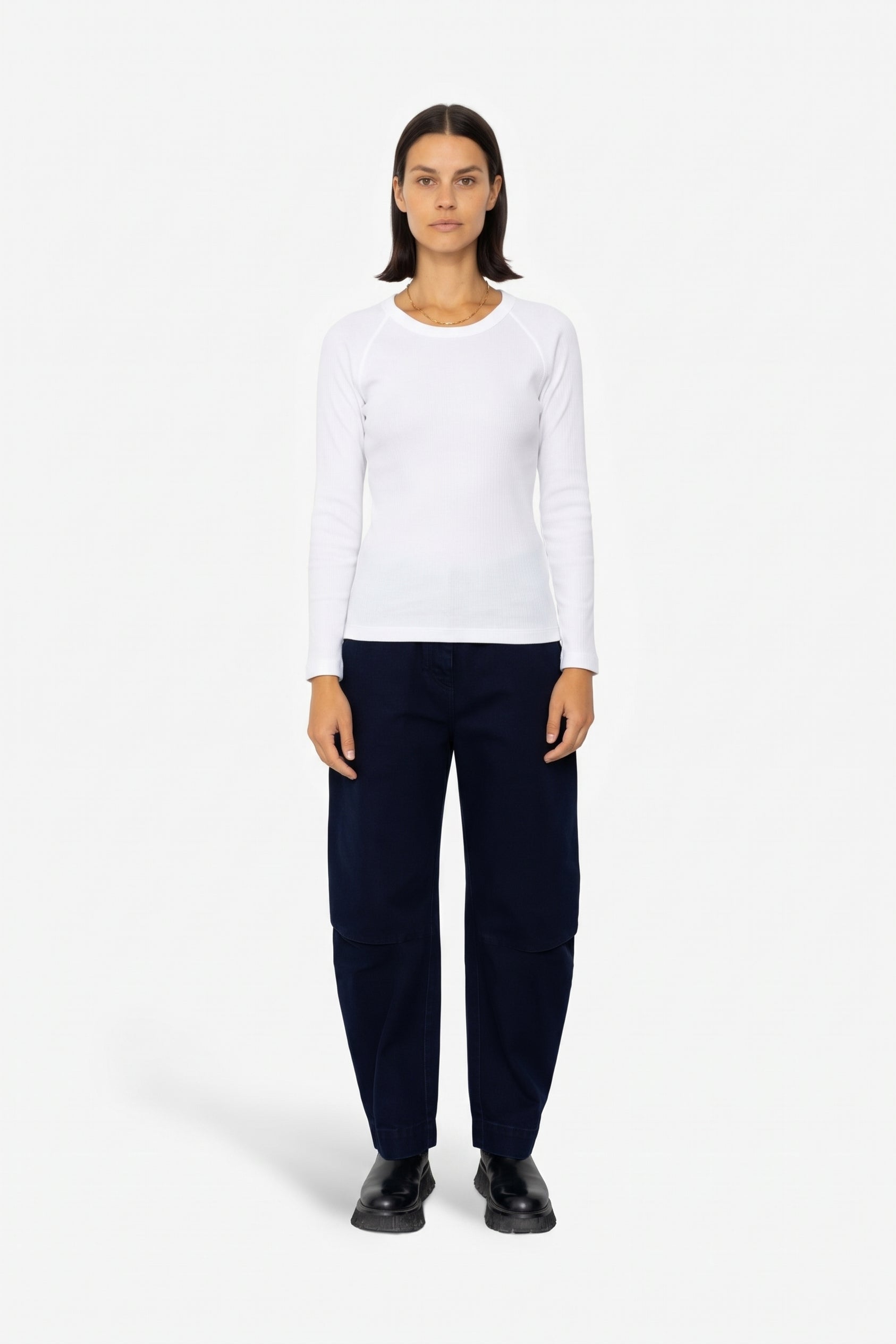 Woman wearing long sleeve white t-shirt and navy trousers