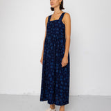 Woman wearing a dark blue patterned dress against a white background