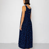 Woman wearing a dark blue patterned dress against a white background