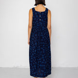 Woman wearing a dark blue patterned dress against a white background