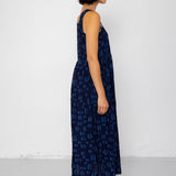 Woman wearing a dark blue patterned dress against a white background