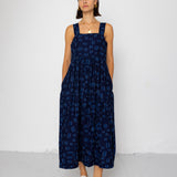 Woman wearing a navy blue patterned dress against a white background