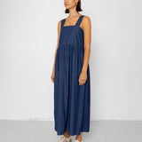 Woman wearing a blue dress standing against a white background