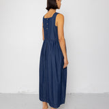 Woman wearing a blue dress standing against a white background