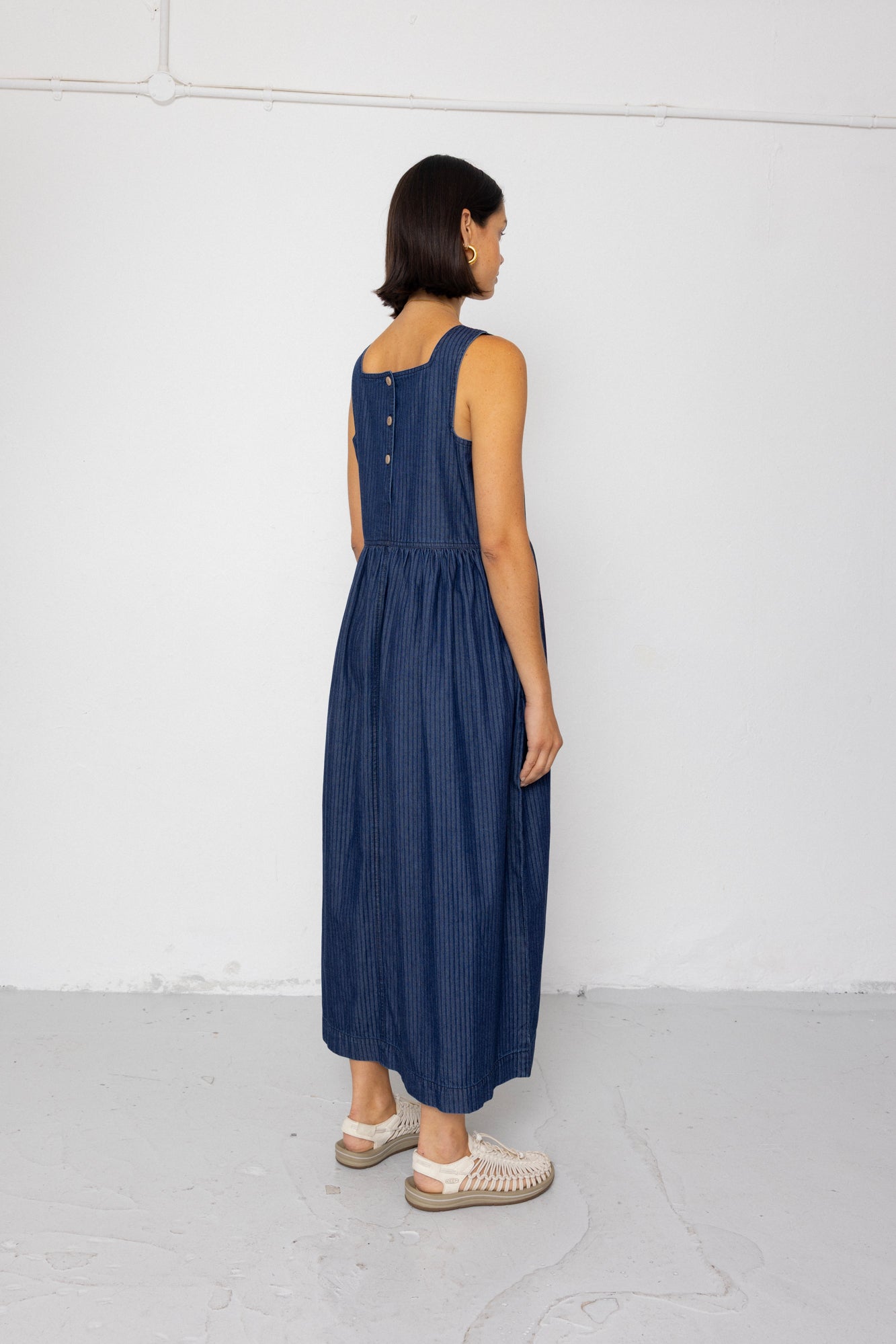 Woman wearing a blue dress standing against a white background