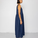 Woman wearing a blue dress standing against a white background