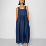 Woman wearing a blue dress standing against a white background