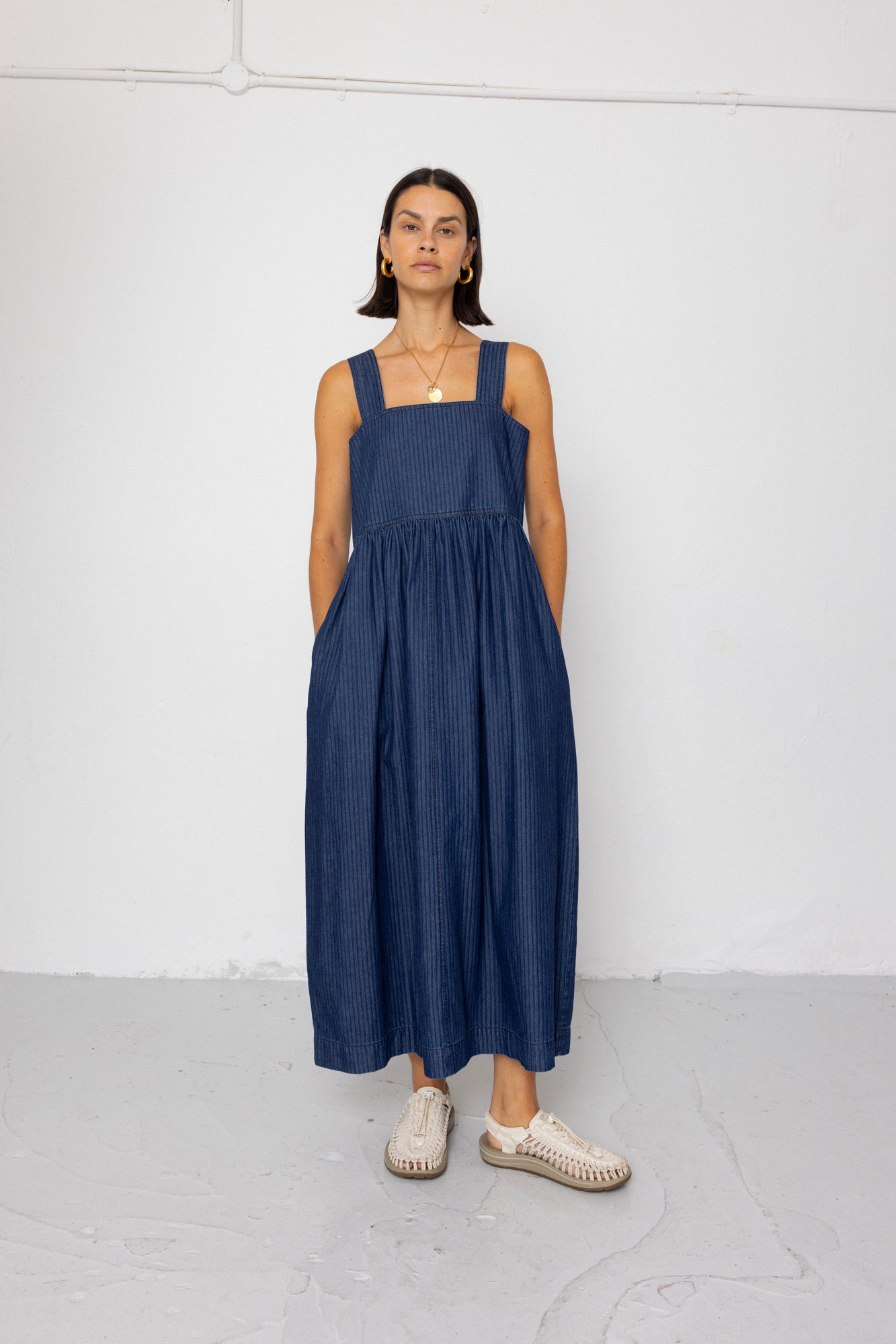 Woman wearing a blue dress standing against a white background