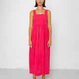 Woman wearing a pink dress standing against a white background