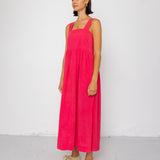 Woman wearing a pink dress standing against a white background