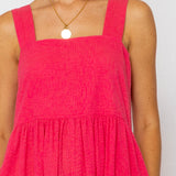 Person wearing a pink dress with a white background
