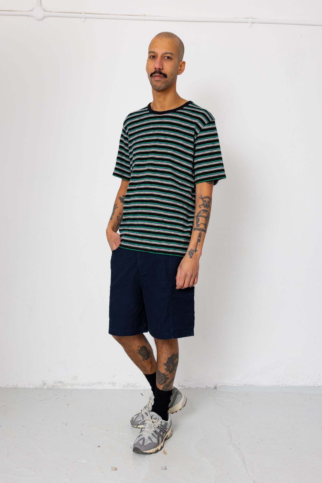 Man wearing a striped shirt and shorts against a white background