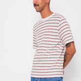 Man wearing a striped shirt and jeans against a white background