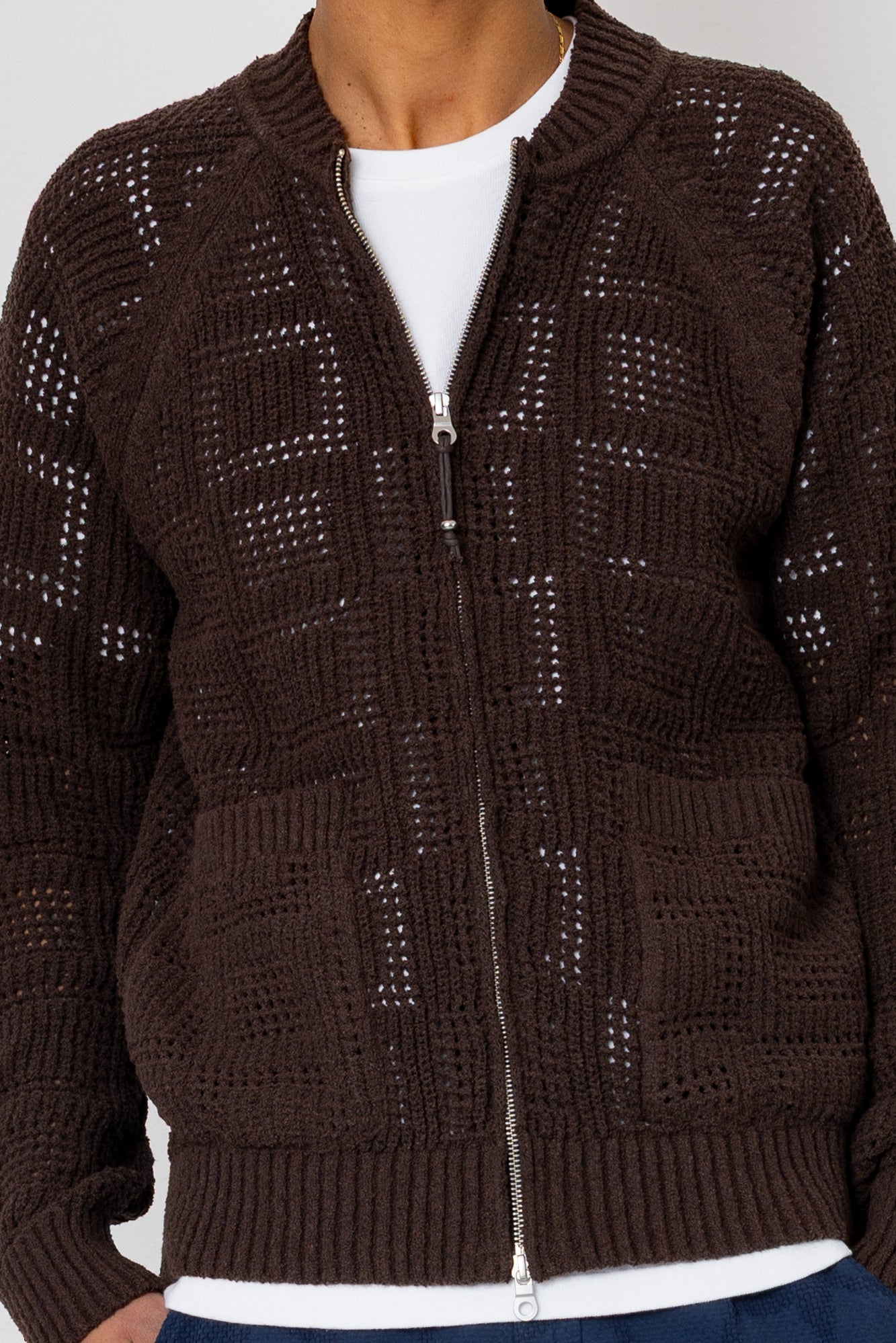 Brown knitted zip-up cardigan worn by a person on a white background