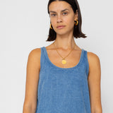 Woman wearing a denim tank top on a plain background