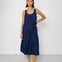 Woman wearing a navy blue sleeveless top and skirt against a white background