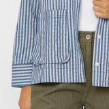 Person wearing a blue and white checkered shirt with a white background