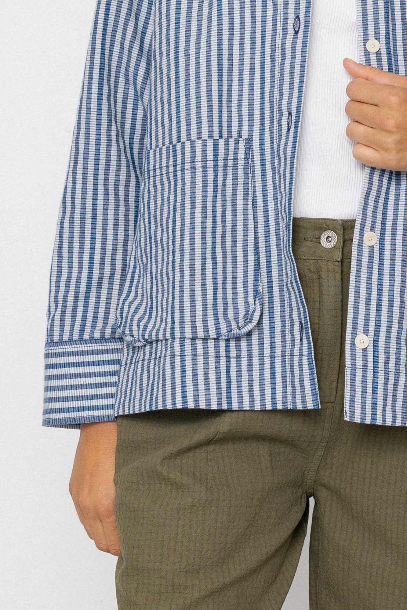 Person wearing a blue and white checkered shirt with a white background