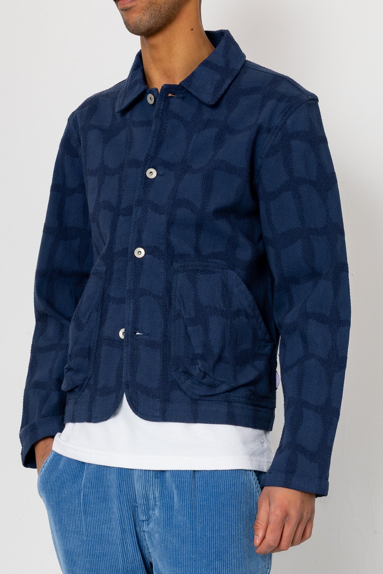 Person wearing a blue patterned jacket on a white background