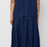 Person wearing a navy blue textured outfit against a white background