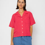 Person wearing a red shirt and blue shorts on a white background