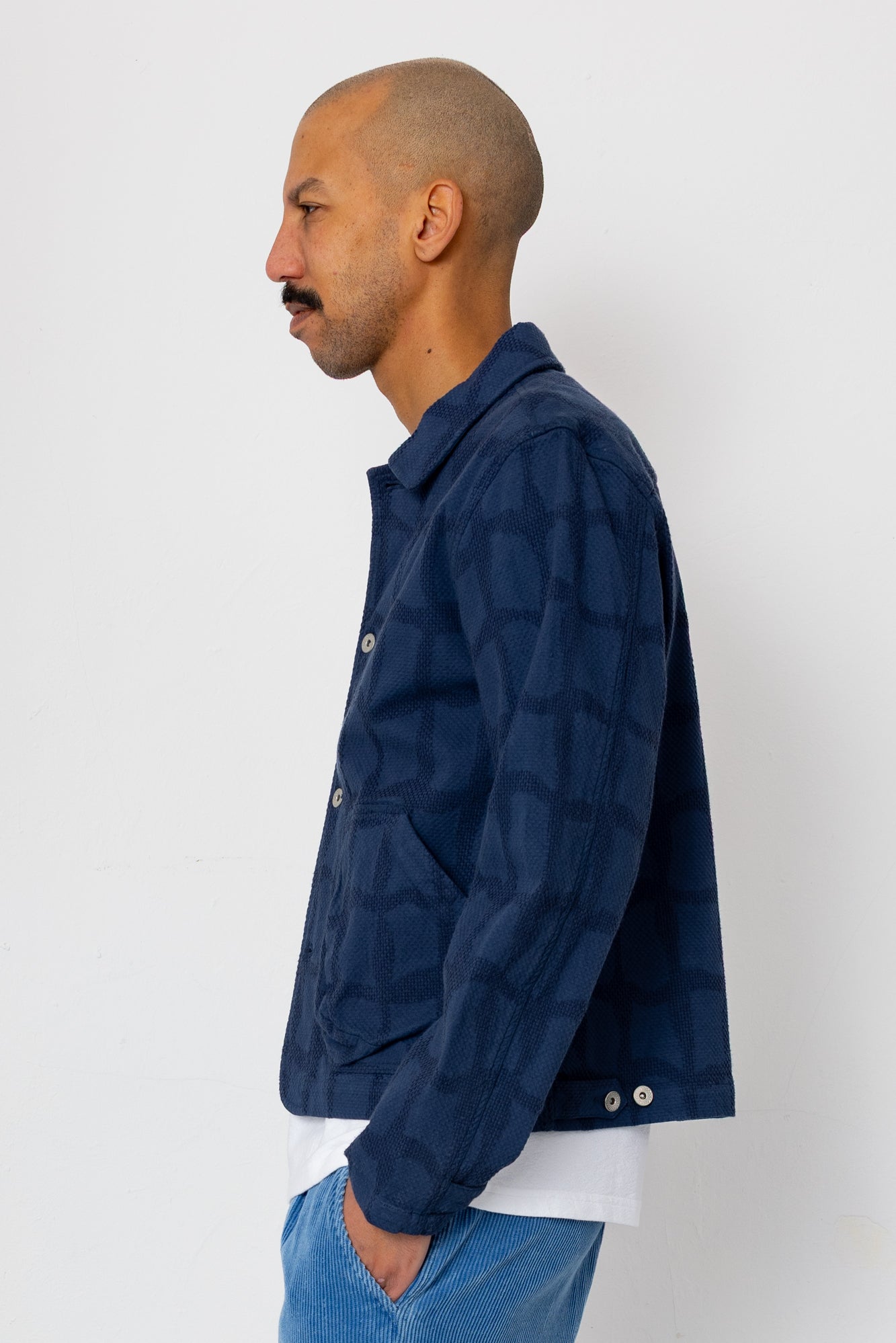 Man wearing a navy blue jacket against a white background