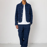 Man wearing a navy quilted jacket and pants against a white background