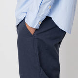 Light blue shirt and navy pants on a plain background