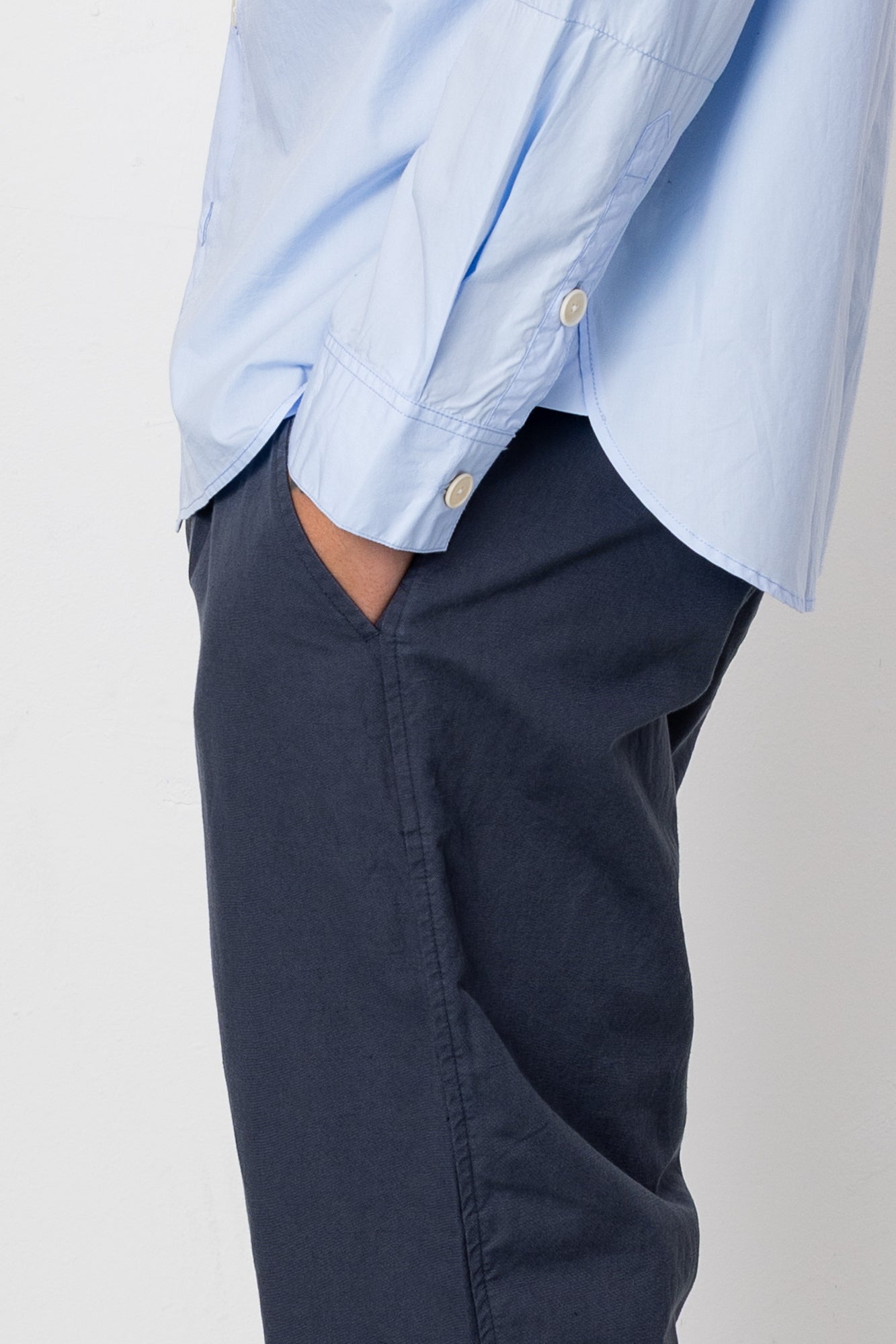 Light blue shirt and navy pants on a plain background