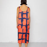 Person wearing a sleeveless dress with a geometric pattern on a white background