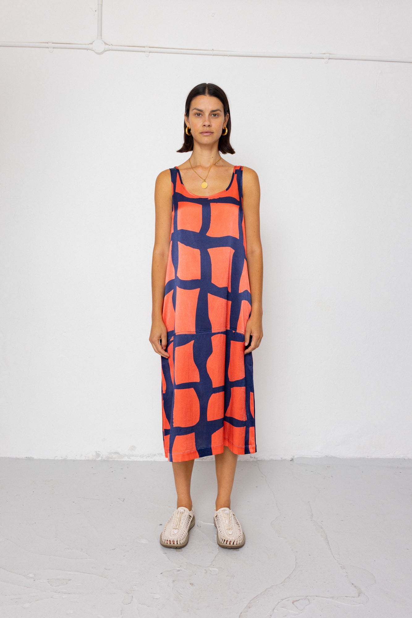 Woman wearing a patterned dress against a white background