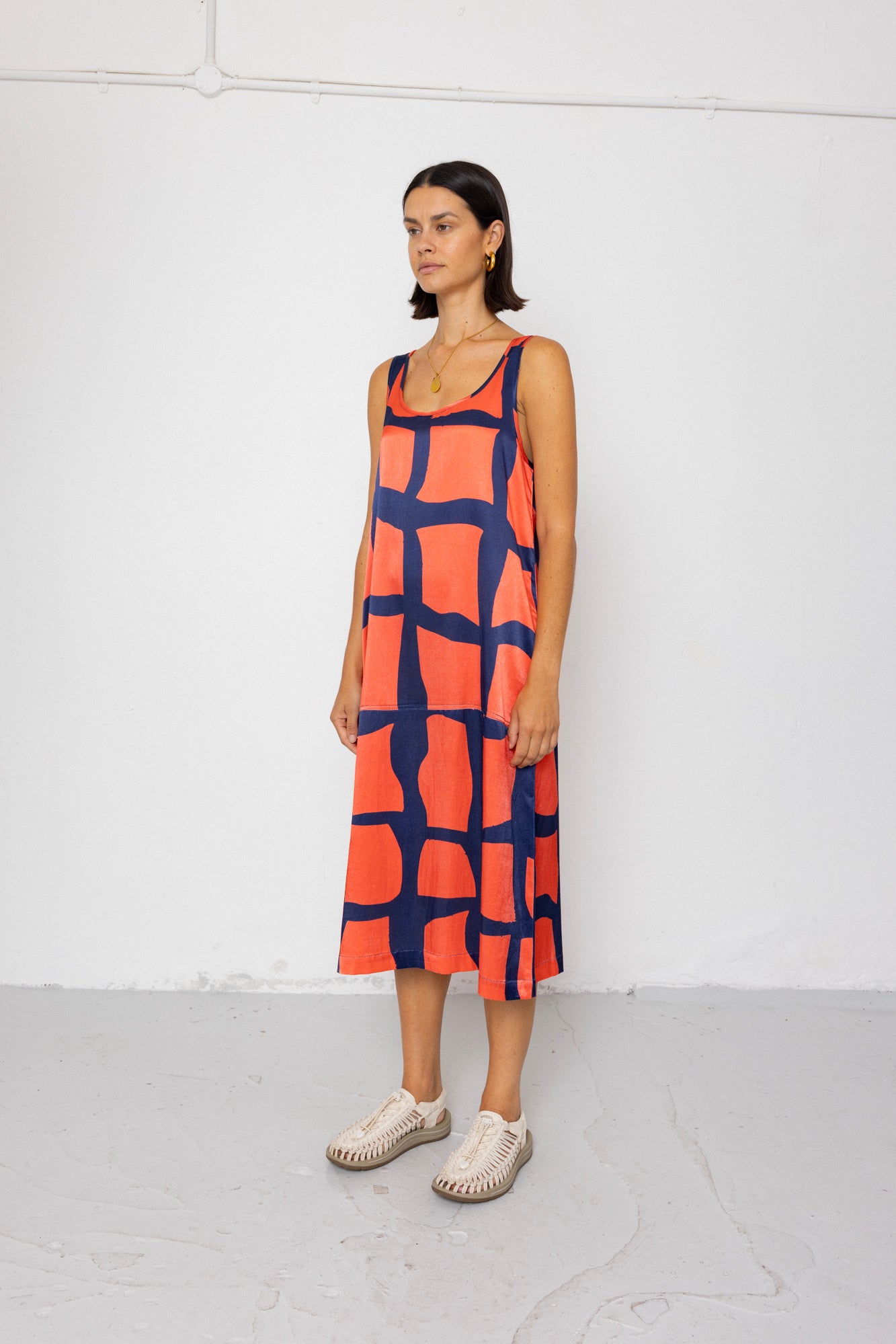 Woman wearing a patterned dress against a white background