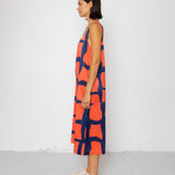 Woman wearing a sleeveless dress with a geometric pattern on a white background