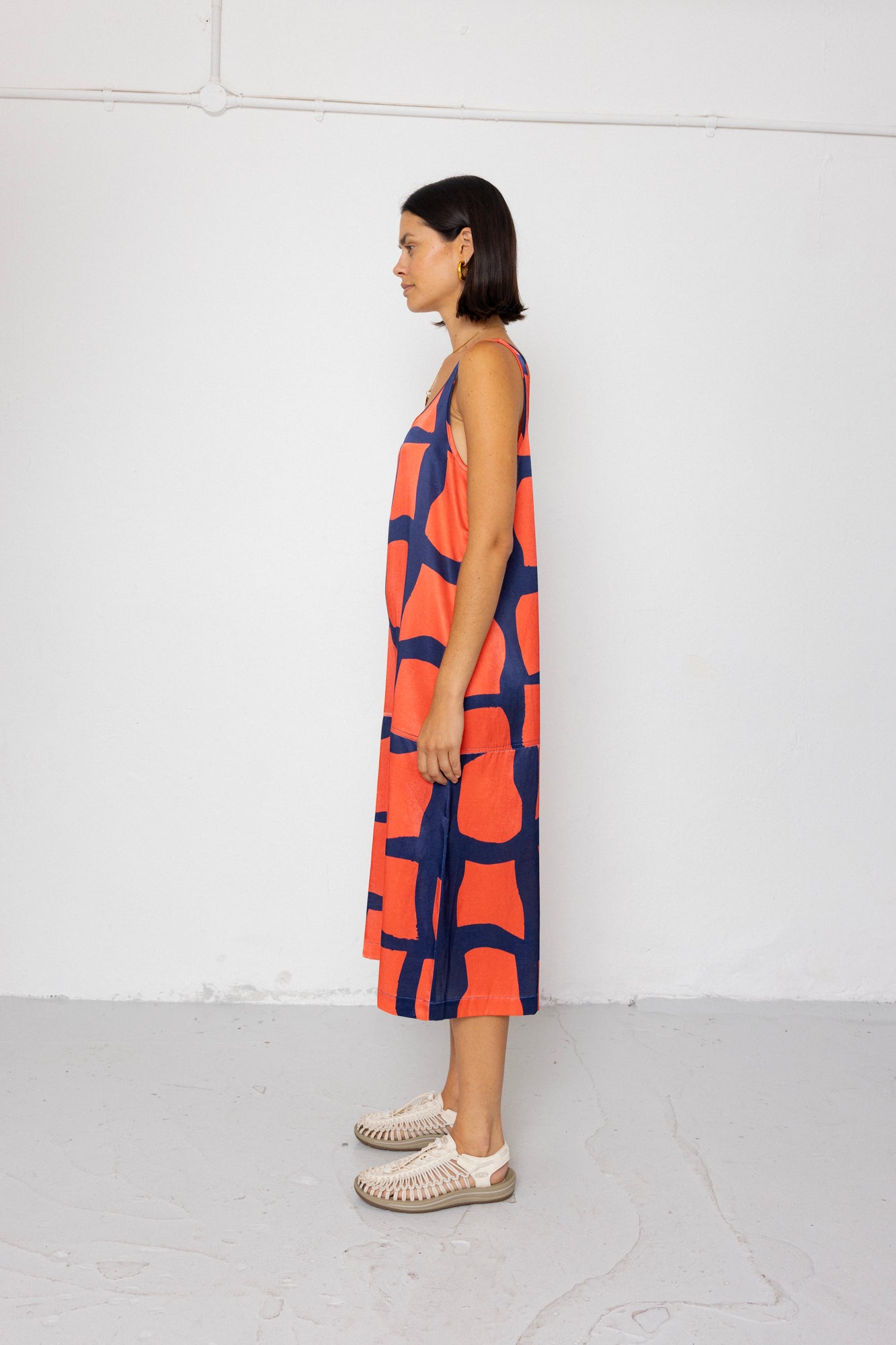 Woman wearing a sleeveless dress with a geometric pattern on a white background