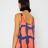 Woman wearing a sleeveless dress with a geometric pattern on a white background