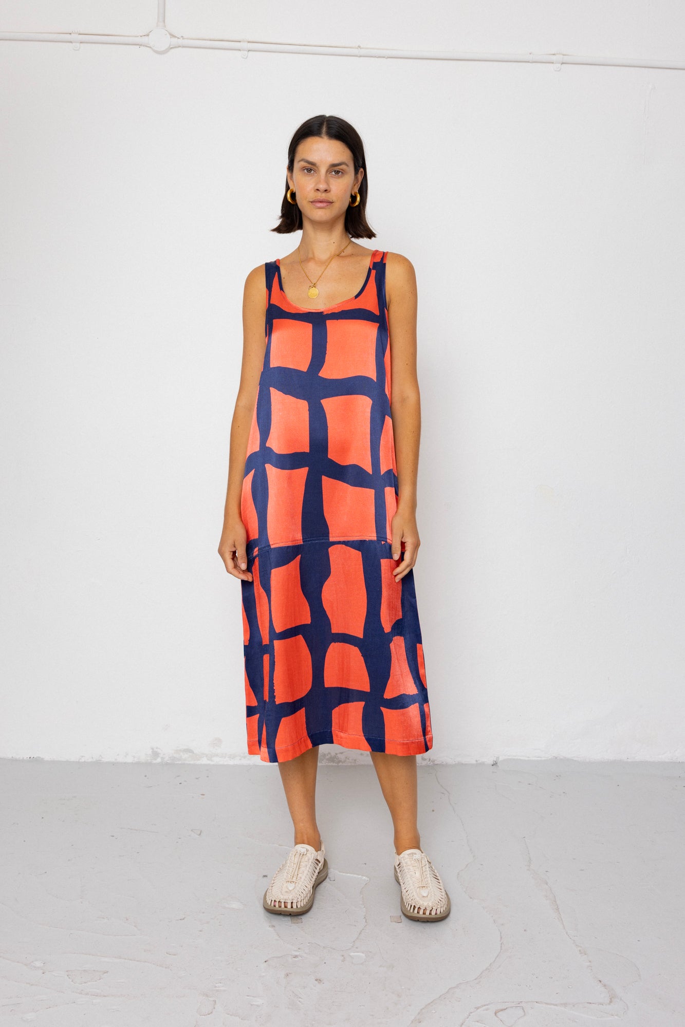 Woman wearing a red and blue patterned dress on a white background