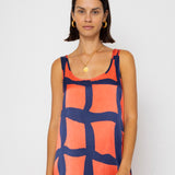 Woman wearing a sleeveless dress with a geometric pattern on a white background