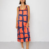 Woman wearing a sleeveless dress with a geometric pattern on a white background