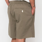 Person wearing olive green shorts on a white background