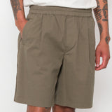 Person wearing olive green shorts on a white background